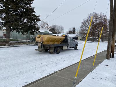 Photo showing truck applying gravel to city roads