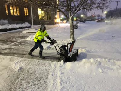 Photo of worker removing snow from walkway