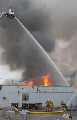 eagles_fire_2.jpg Firefighter in a "bucket" at the end of the extendable ladder attached to a fire truck as he douses a fire in water from a canon