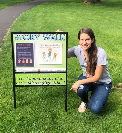 Library Director at Community Park with Story Walk Sign